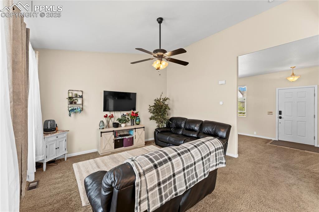 Living area featuring carpet floors and ceiling fan