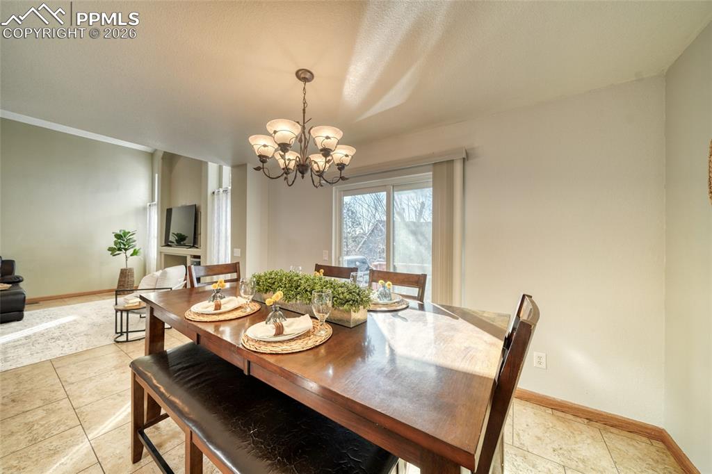 Dining room with suspended lighting and light tile patterned flooring