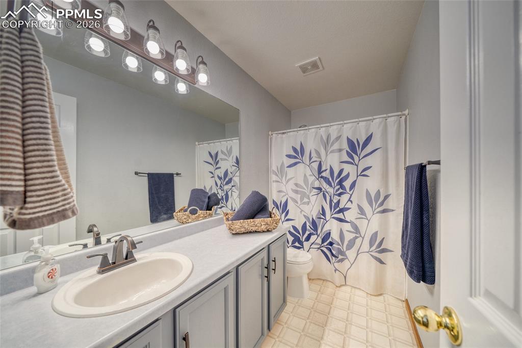Full bathroom with vanity, light flooring, and a shower with curtain