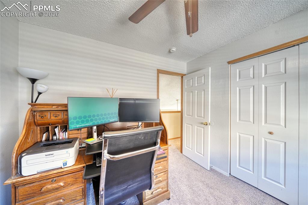 Office featuring light colored carpet, a textured ceiling, and a ceiling fan