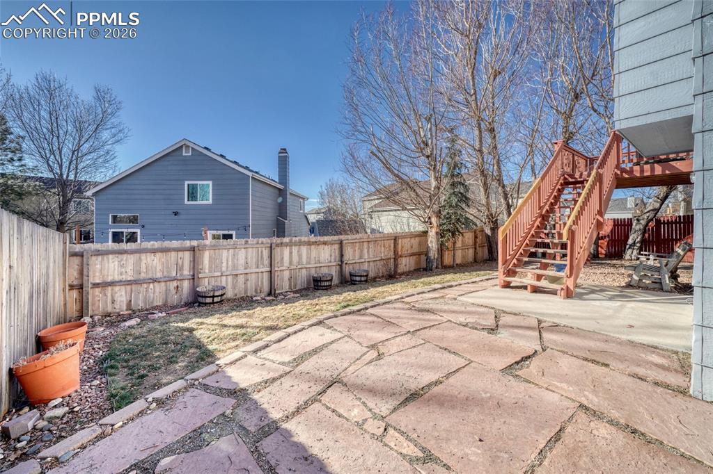 Fenced backyard featuring a patio area and stairway