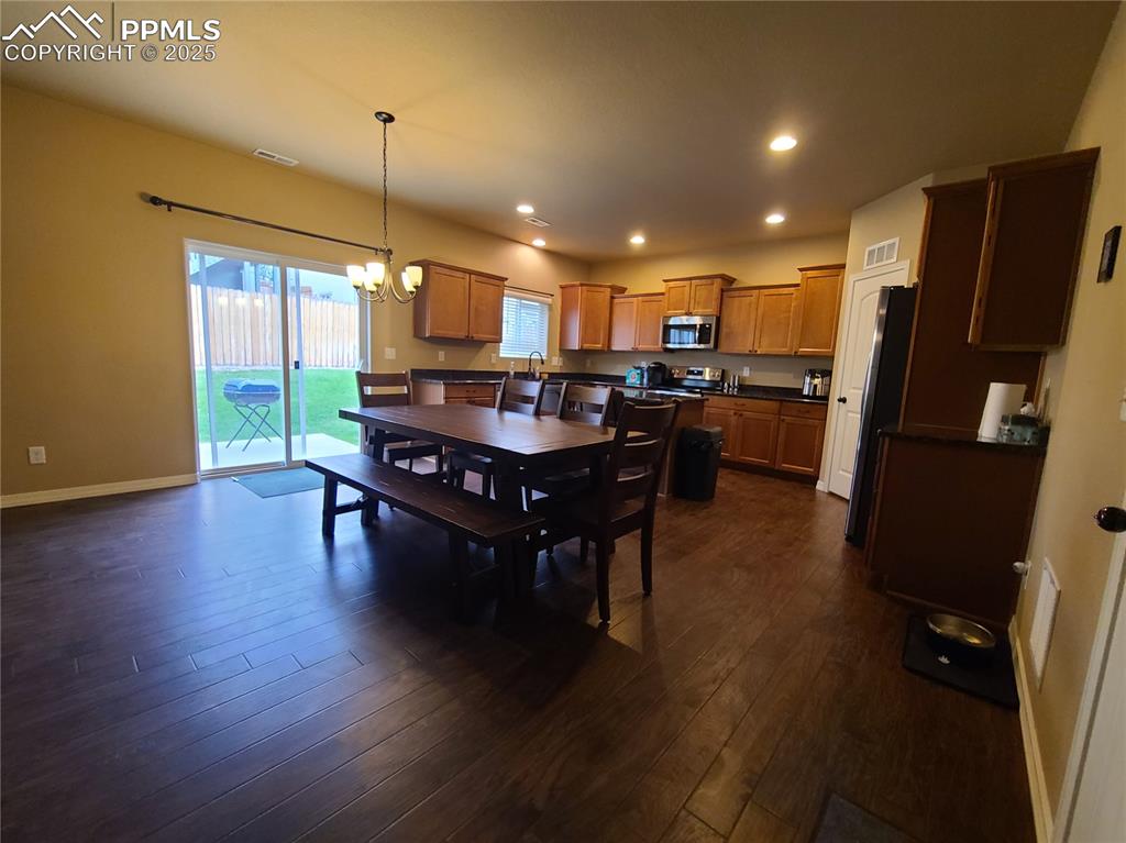 Dining area featuring recessed lighting, a chandelier, and dark wood-style floors