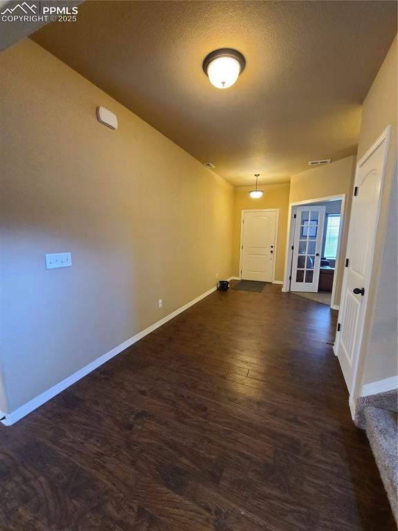 Hallway featuring dark wood-type flooring and a textured ceiling