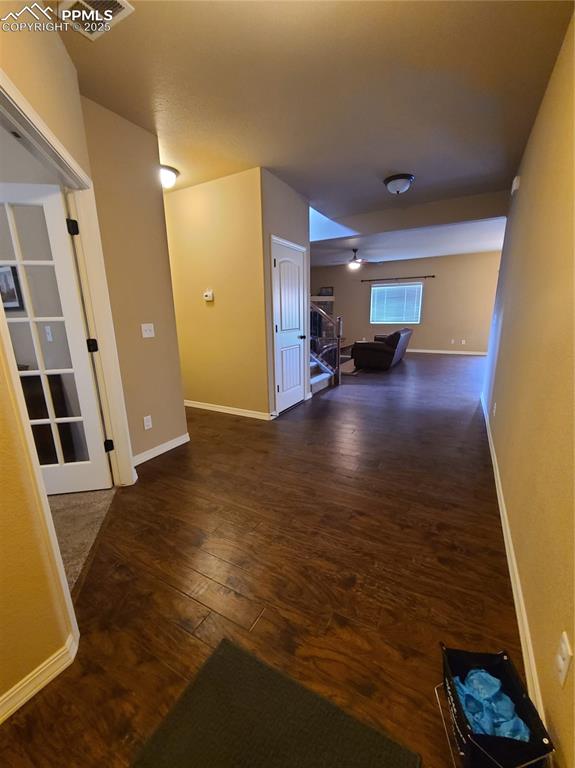 Hall with dark wood-style flooring and stairway