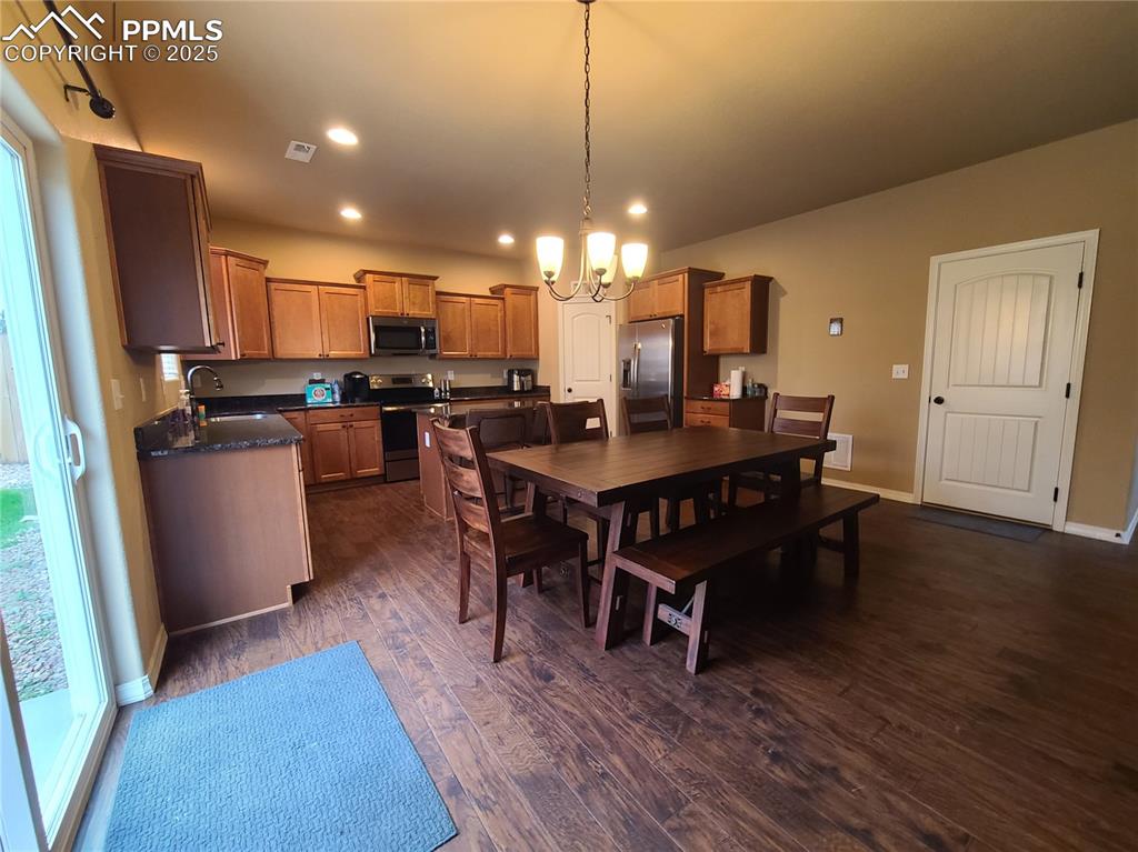 Dining space featuring a chandelier, recessed lighting, dark wood finished floors, and plenty of natural light