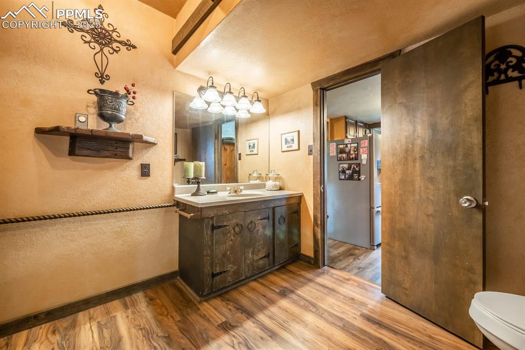 Bathroom featuring vanity, wood-type flooring, and toilet