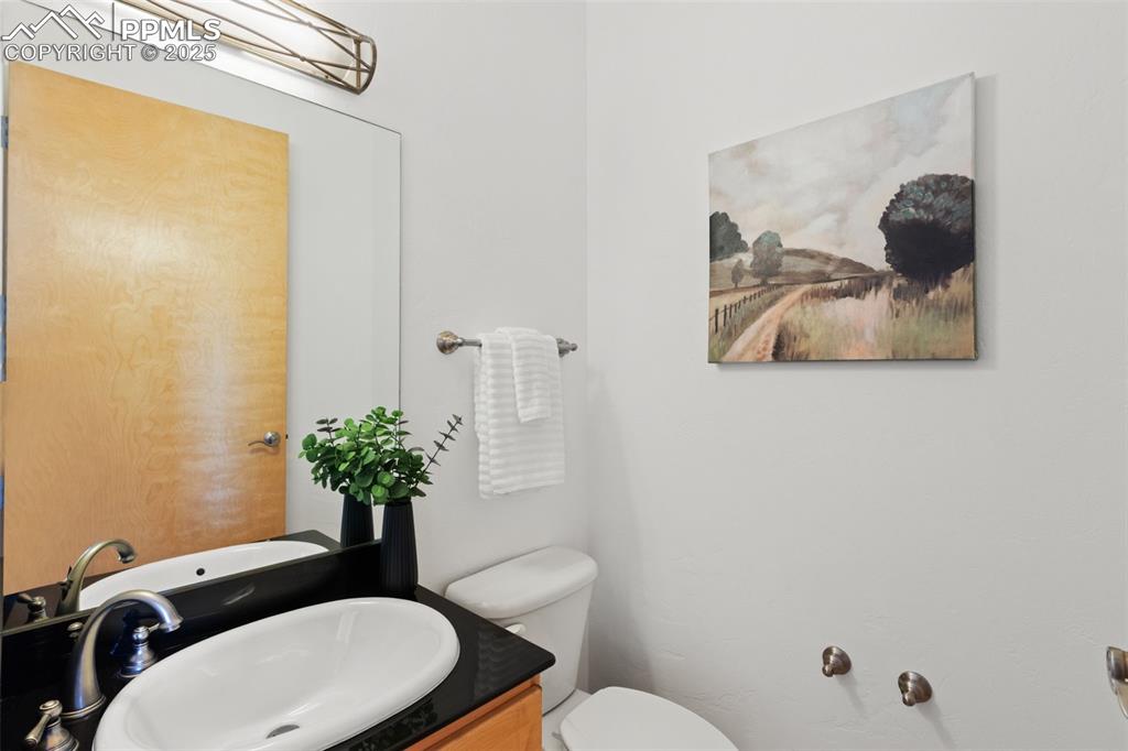 Half bathroom featuring vanity and toilet