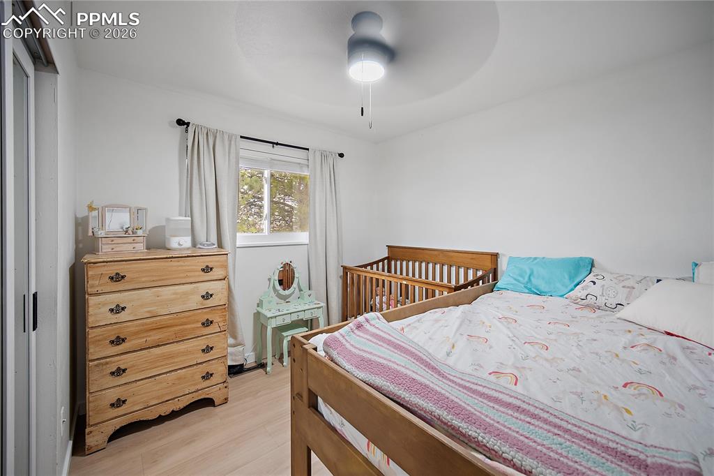 Main level bedroom with laminate flooring and ceiling fan. 