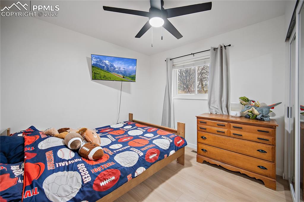 Main level bedroom with laminate flooring and ceiling fan. 