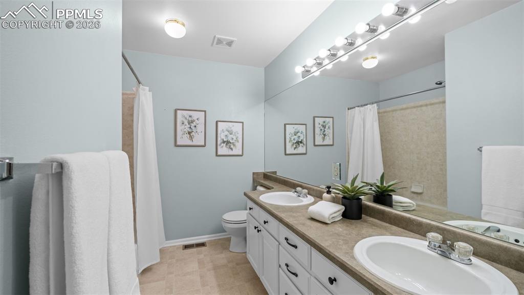 Bathroom featuring double vanity and curtained shower
