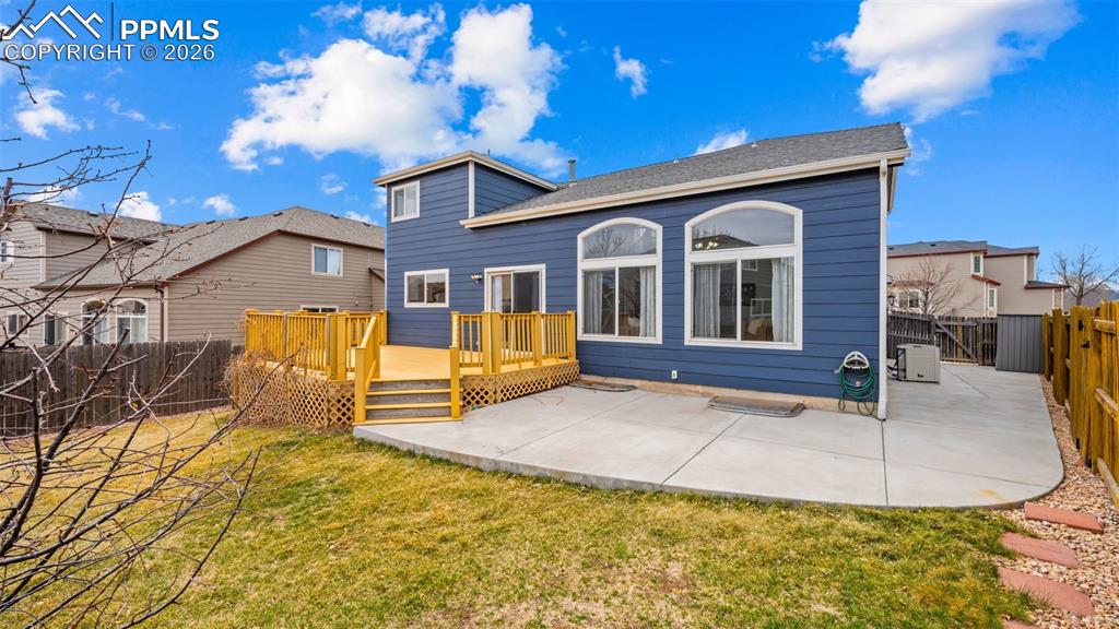 Rear view of house with a fenced backyard, a patio area, and a deck