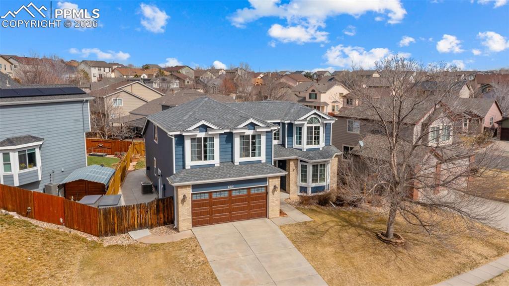 Traditional-style home featuring concrete driveway, an attached garage, and a residential view