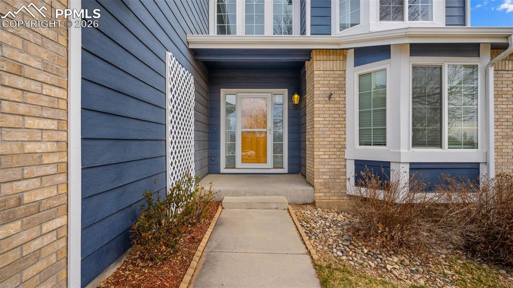 Doorway to property featuring brick siding