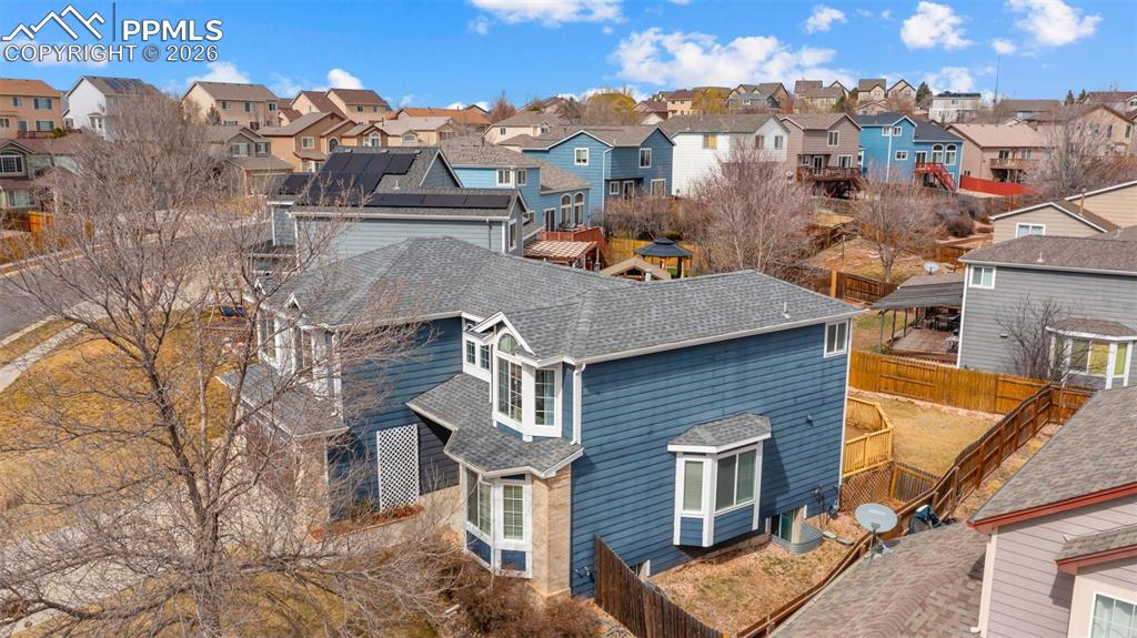View of home's exterior featuring roof with shingles, solar panels, and a residential view