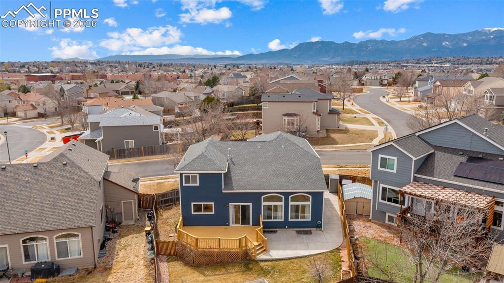Back of house featuring a residential view, a mountain view, a patio, and a fenced backyard