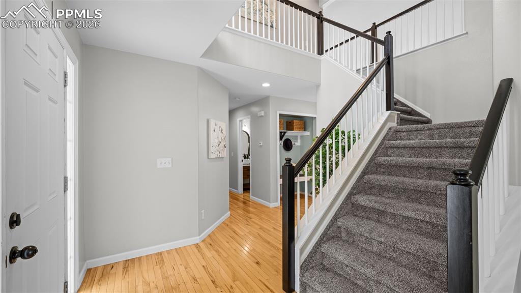 Stairs with wood-type flooring and recessed lighting