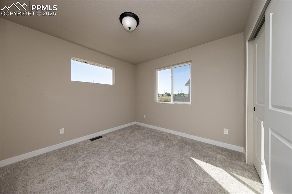 Unfurnished bedroom featuring light colored carpet and a closet