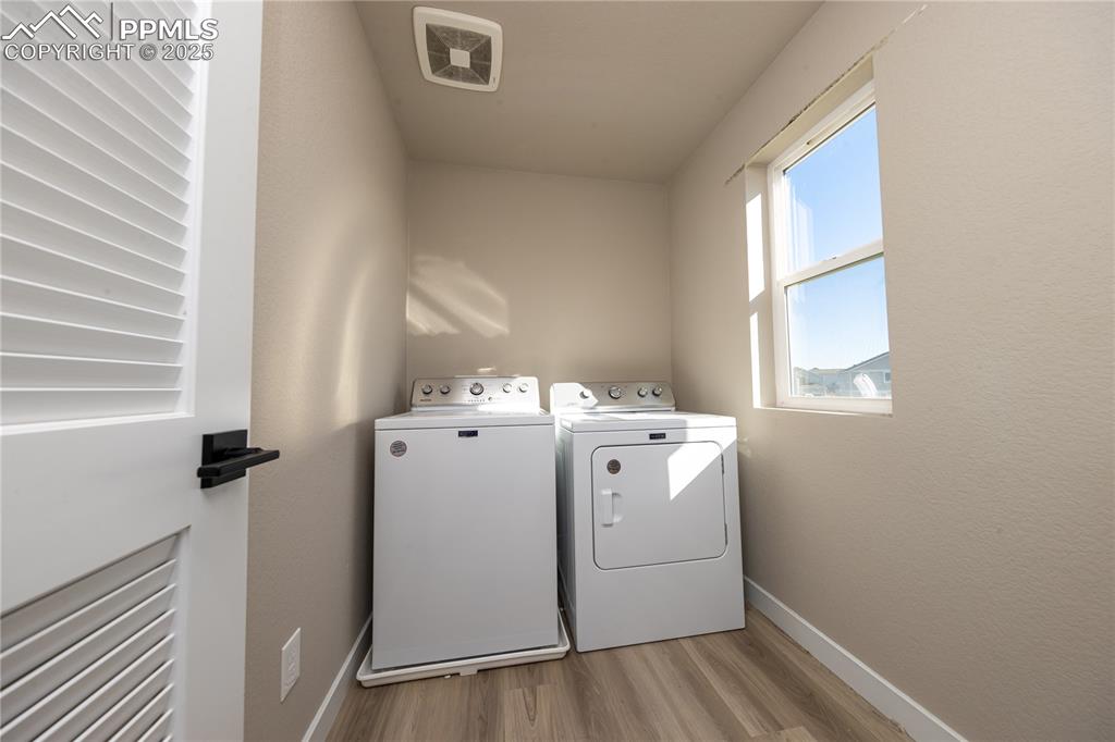 Laundry room with wood finished floors and separate washer and dryer
