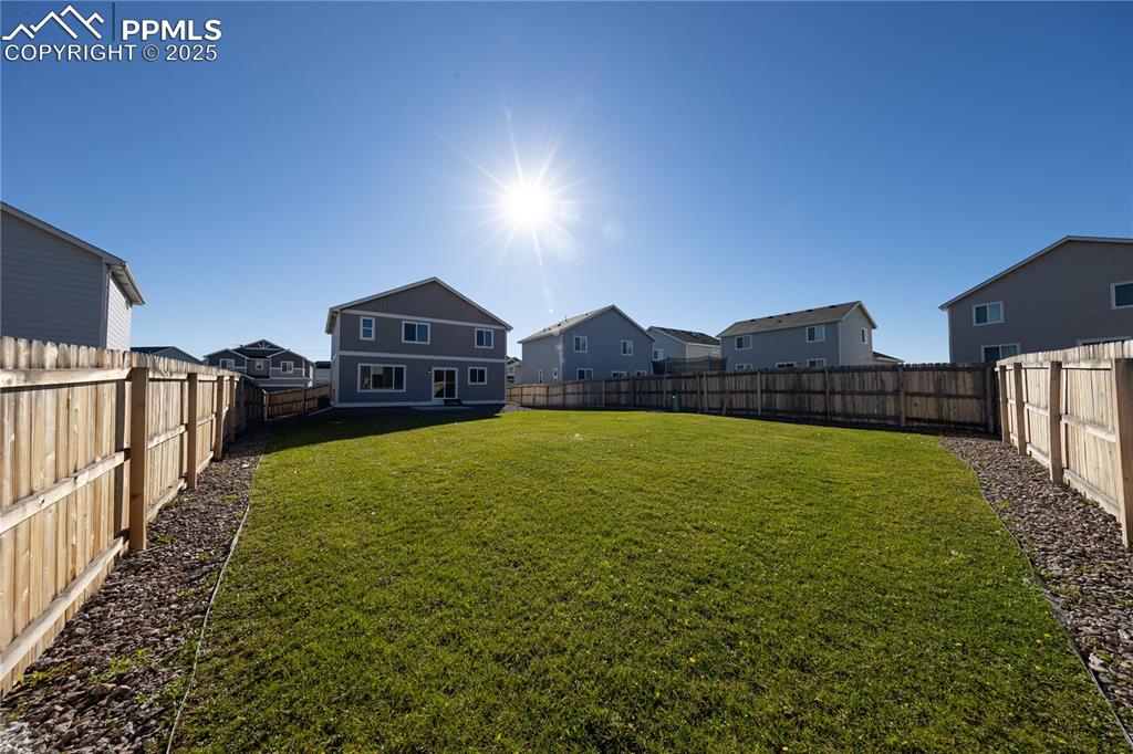 Fenced backyard featuring a residential view