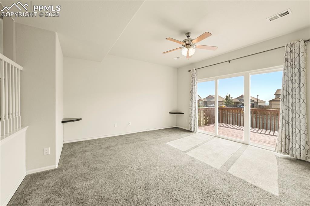 Carpeted spare room with ceiling fan and a residential view