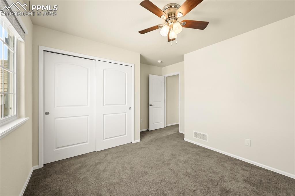 Unfurnished bedroom featuring carpet, a closet, and ceiling fan