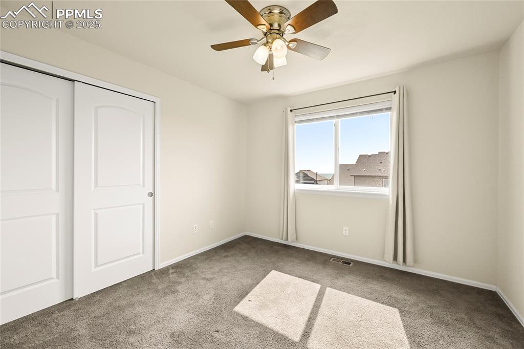 Unfurnished bedroom with light carpet, a closet, and a ceiling fan