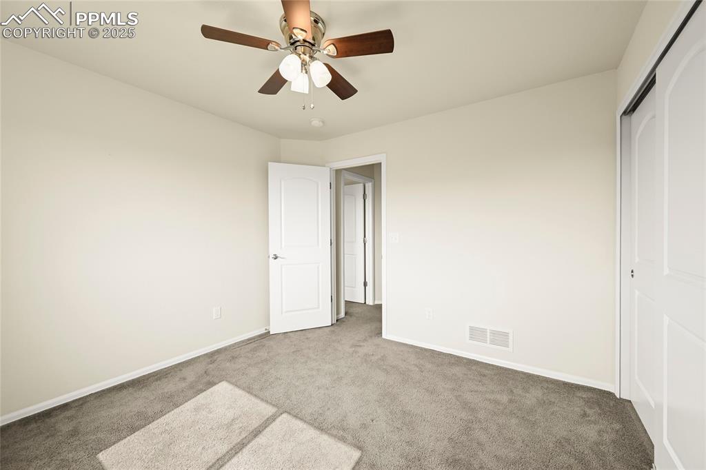 Unfurnished bedroom with carpet flooring, a ceiling fan, and a closet