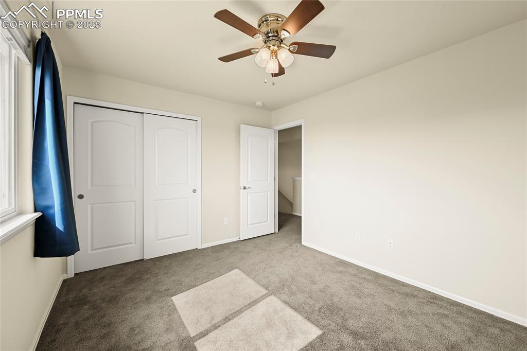 Unfurnished bedroom featuring carpet flooring, a ceiling fan, and a closet