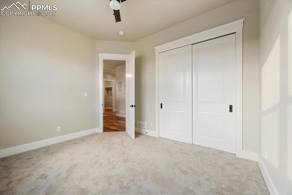Unfurnished bedroom with baseboards, visible vents, a closet, and carpet