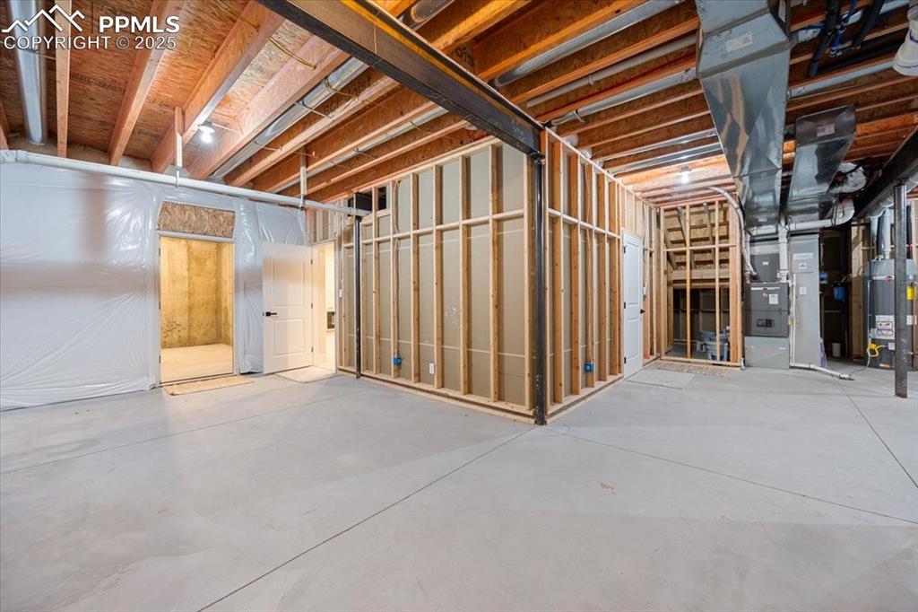 Unfinished basement with heating unit and water heater
