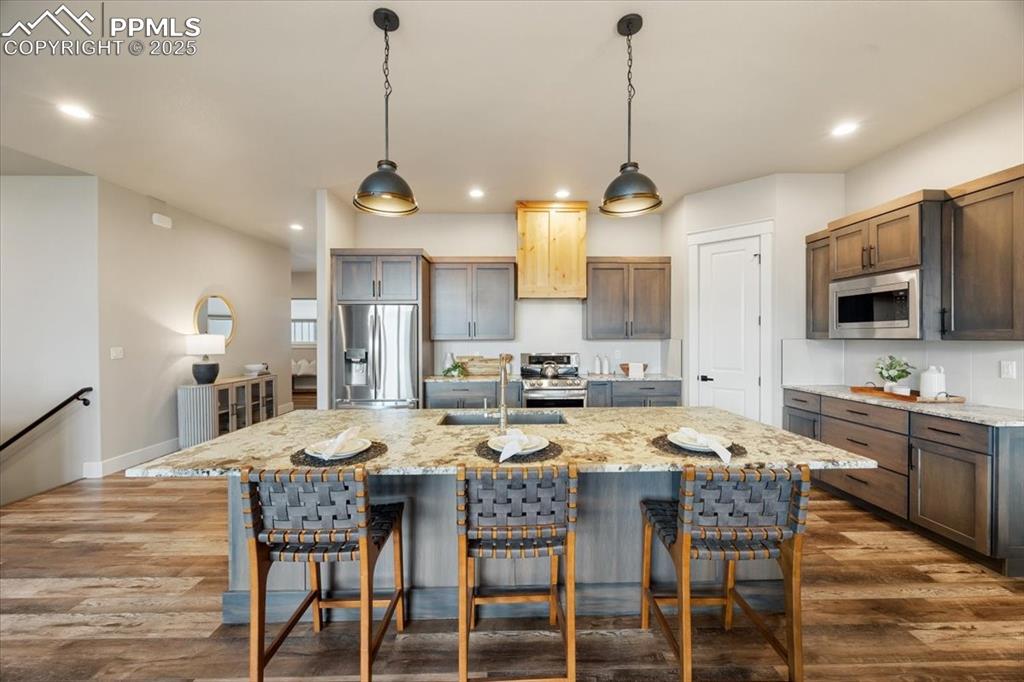 Kitchen featuring recessed lighting, a sink, appliances with stainless steel finishes, and dark wood finished floors
