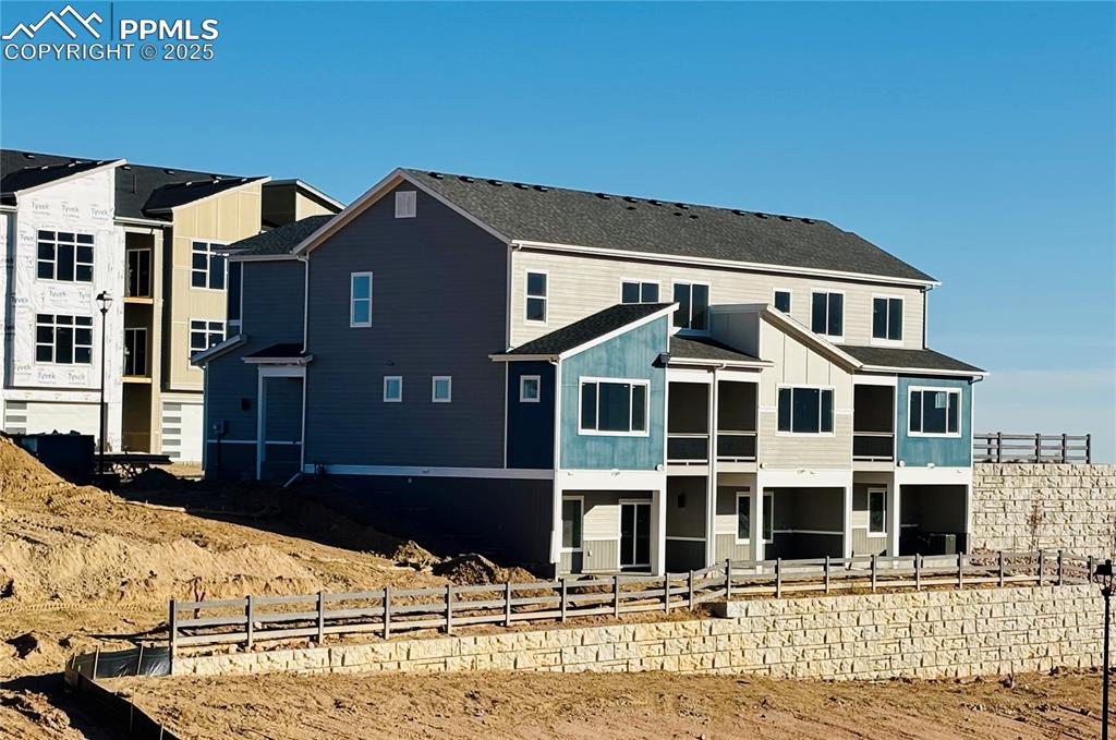Back of house featuring board and batten siding and a shingled roof