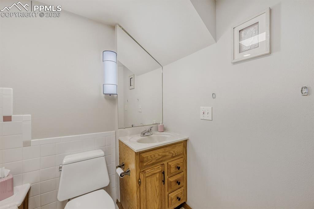 Bathroom featuring vanity, tile walls, and wainscoting