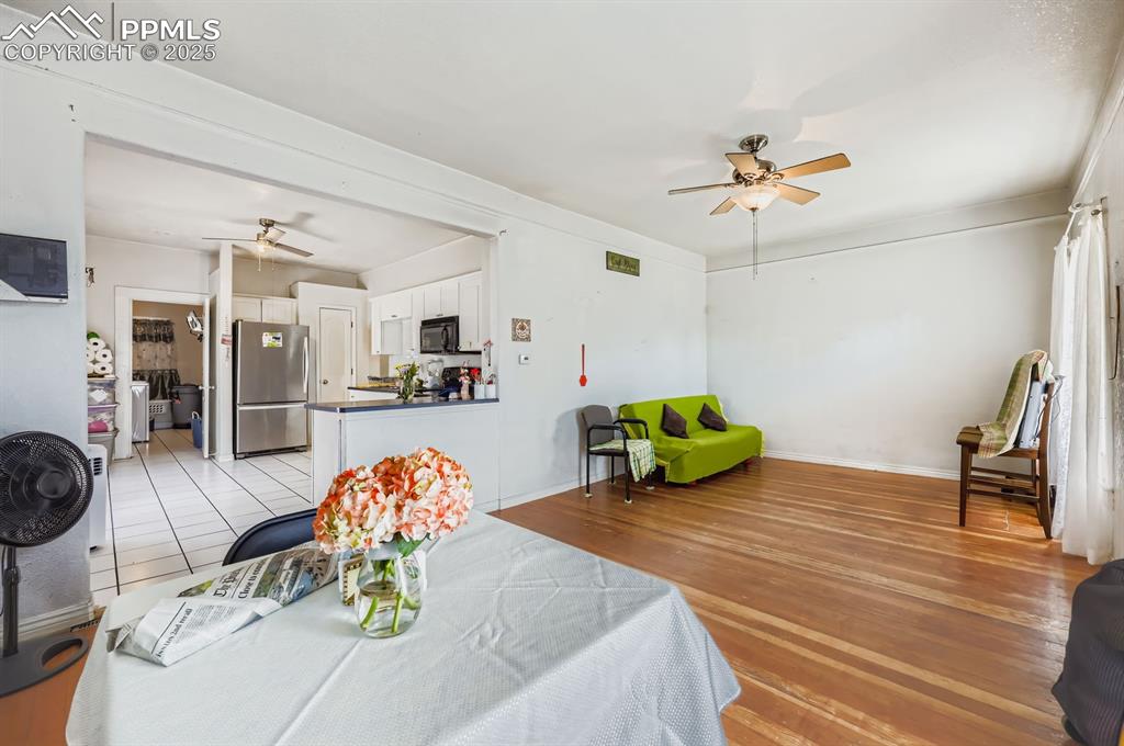 Dining area with a ceiling fan and light wood-style floors