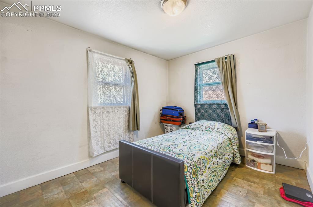 Bedroom with multiple windows and stone finish floors