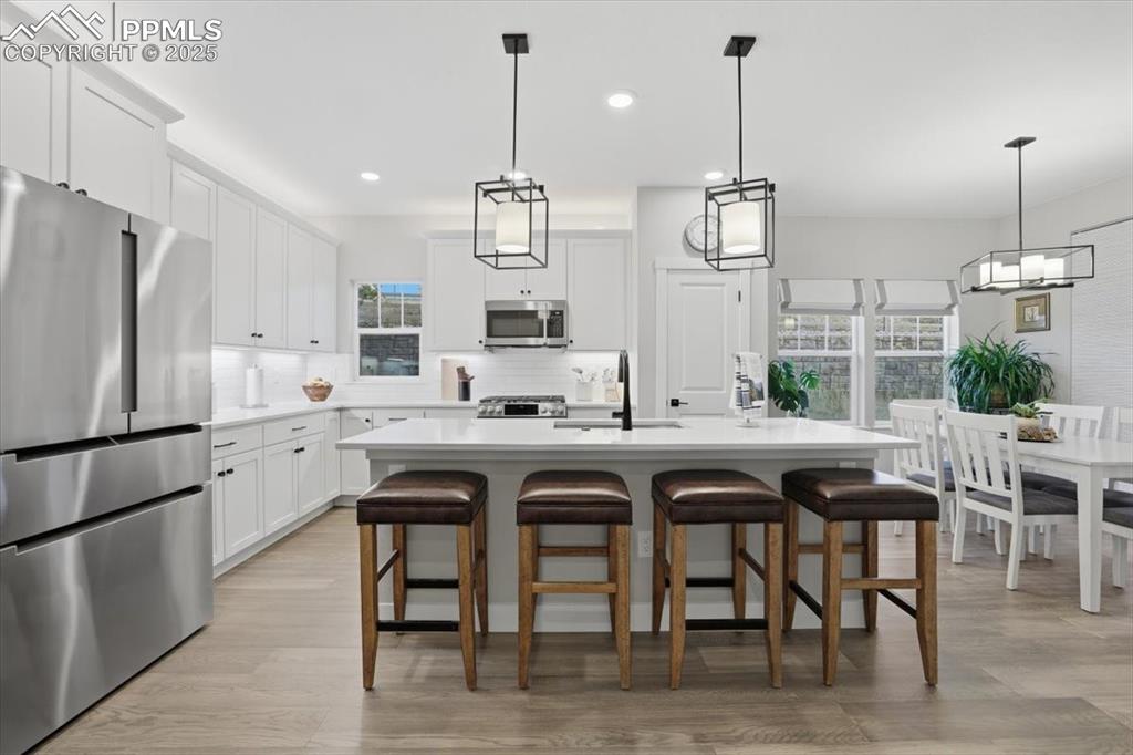 The kitchen island has bar seating and beautiful pendant lights. 