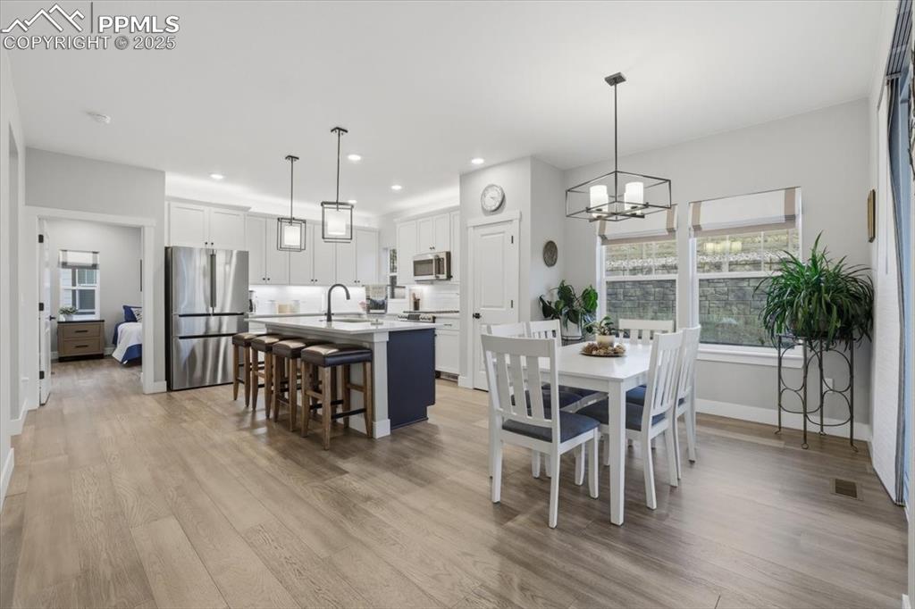 The kitchen and dining area are filled with natural light thanks to the large windows and sliding glass door.
