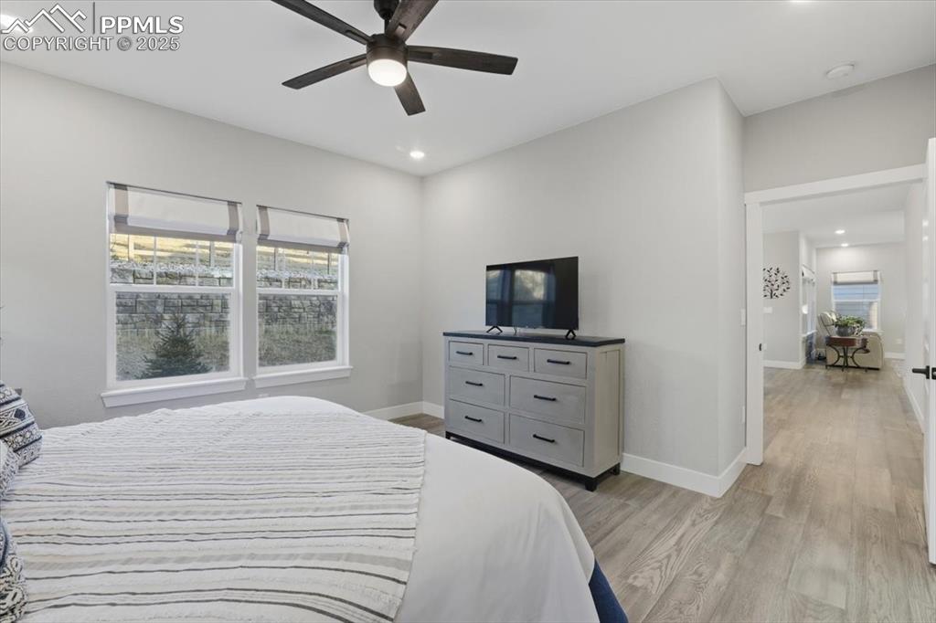 The primary bedroom is located on the main floor and has a ceiling fan and engineered wood floors. 