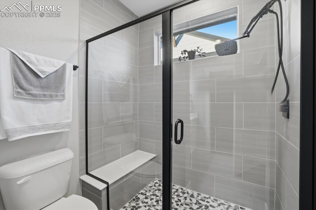 The shower in the primary bath has a built-in seat and a rain shower system.