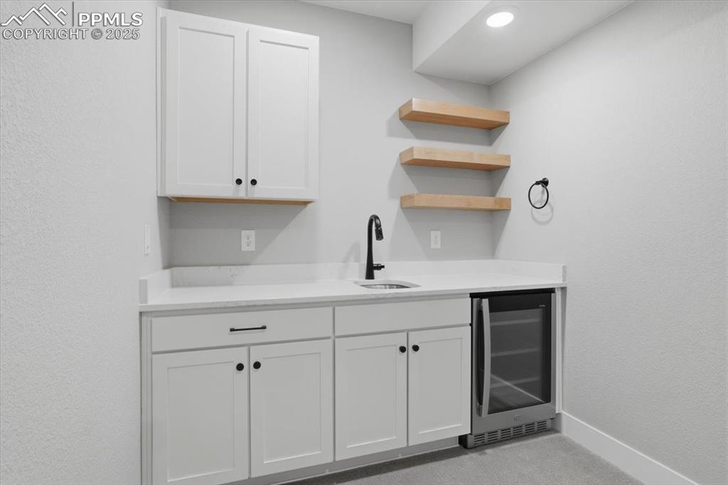 The family room has a built-in wet bar with lots of storage, a wine fridge and open shelving. 