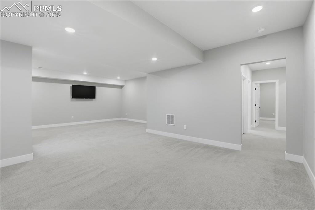 View of the family room from the stairs, toward the back hallway leading to the bedrooms and third bath.