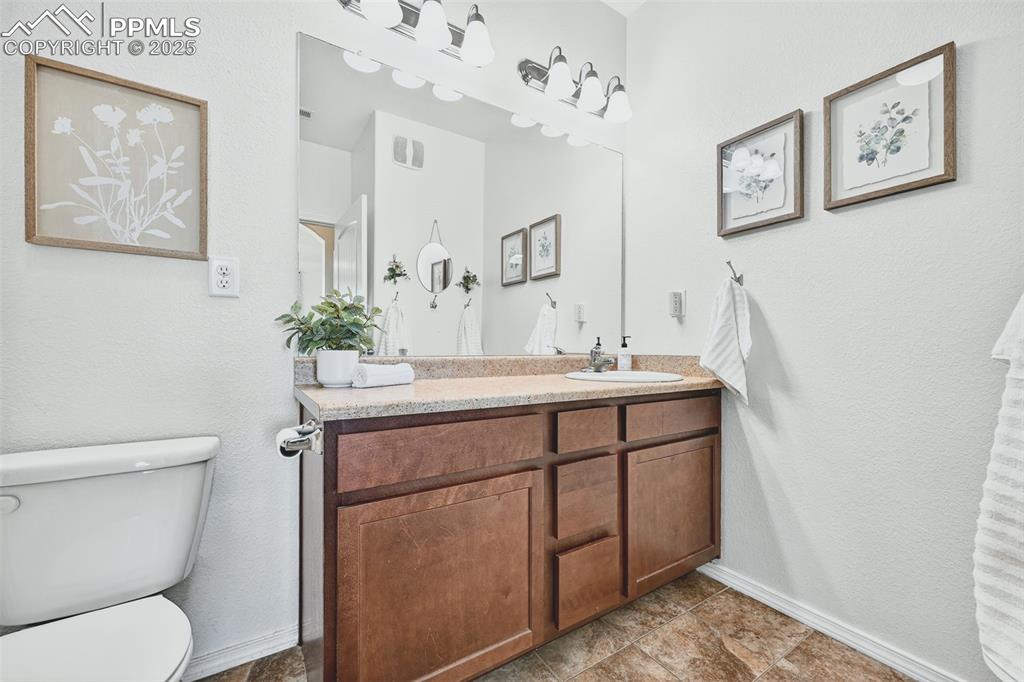 Bathroom featuring a textured wall and vanity