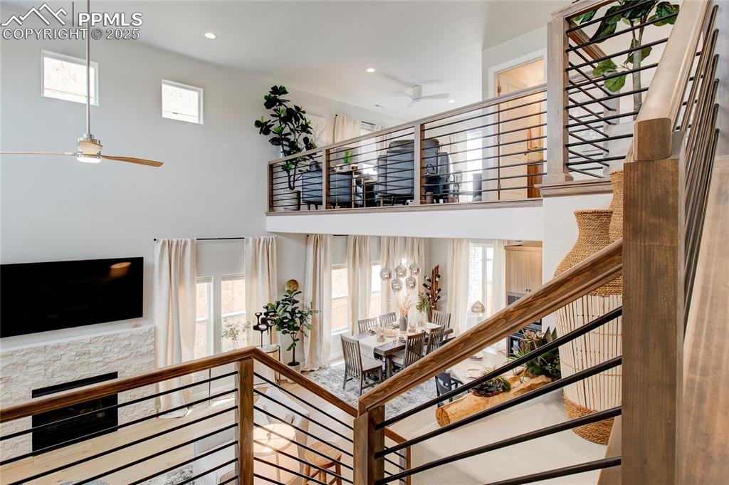 Stairway with ceiling fan, recessed lighting, and a high ceiling