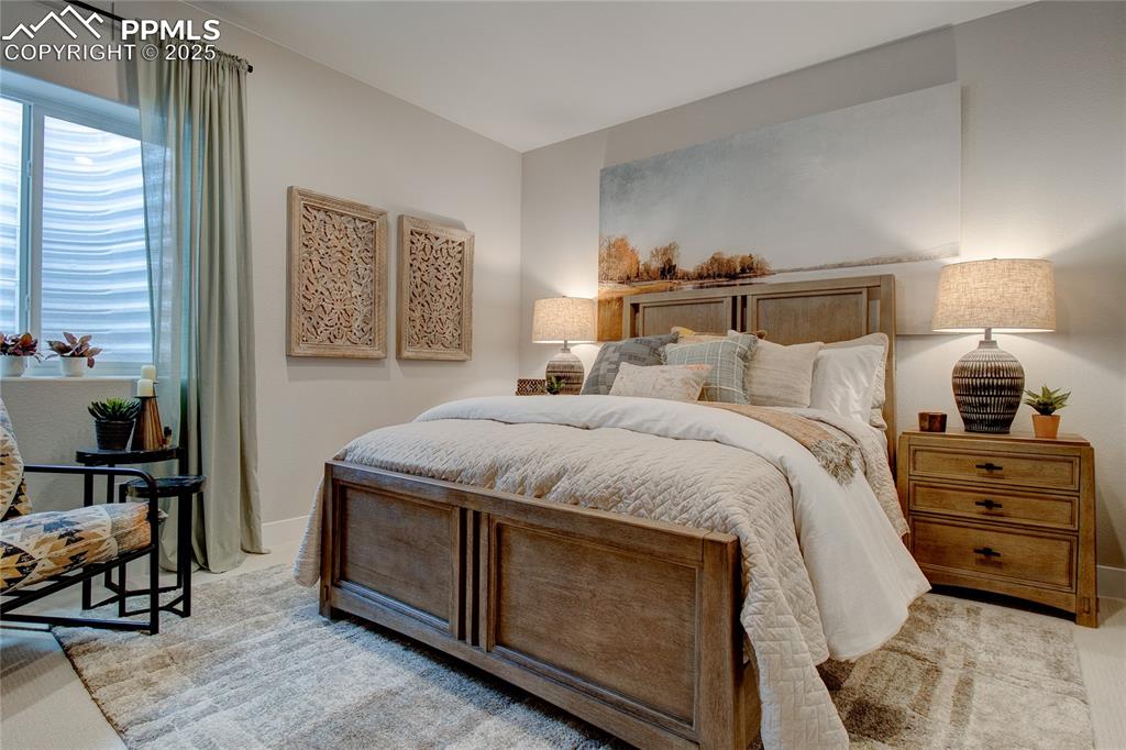 Bedroom with light colored carpet and baseboards
