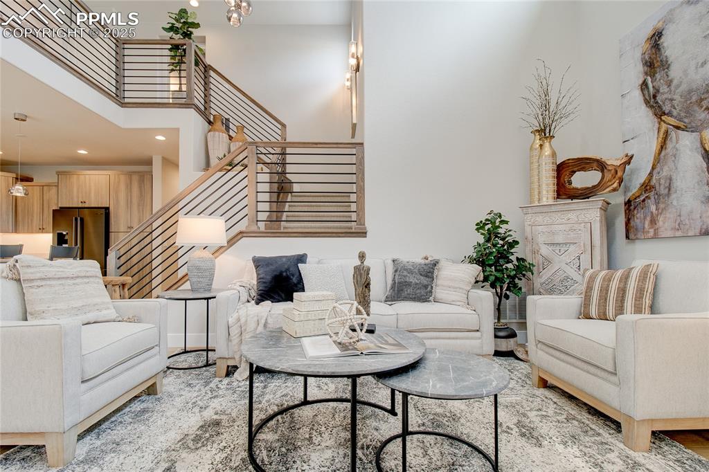 Living room featuring a high ceiling, stairs, recessed lighting, and a chandelier