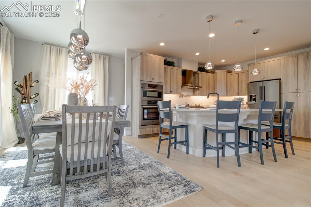 Kitchen with light brown cabinets, modern cabinets, a breakfast bar area, and recessed lighting