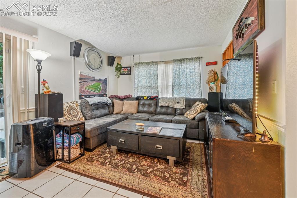 Living room featuring light tile patterned floors and a textured ceiling