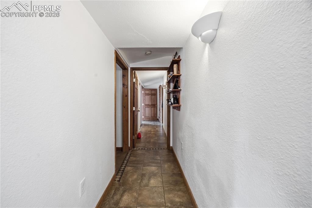 Hall with a textured wall and vaulted ceiling