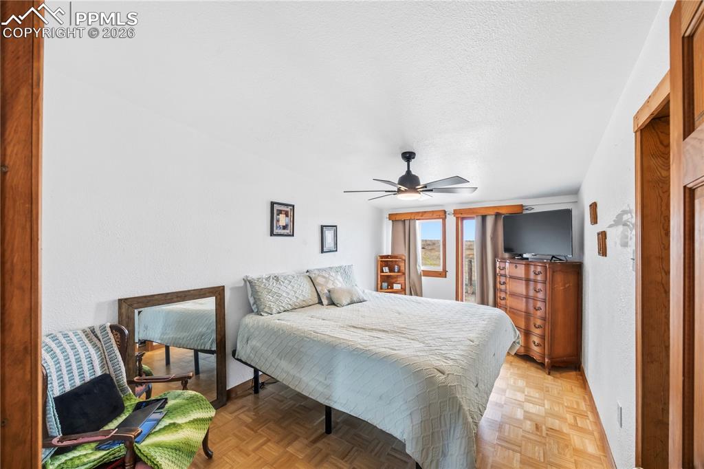 Bedroom featuring parquet flooring, a ceiling fan, and a textured ceiling