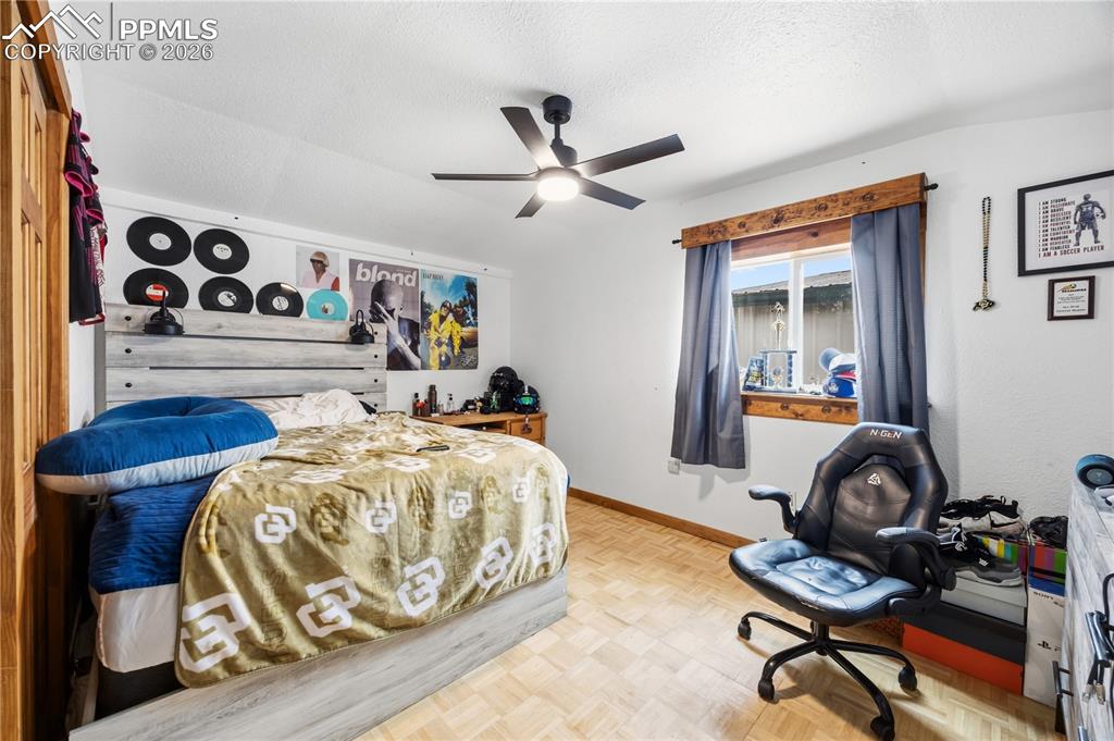 Bedroom featuring parquet flooring, a ceiling fan, and a textured ceiling